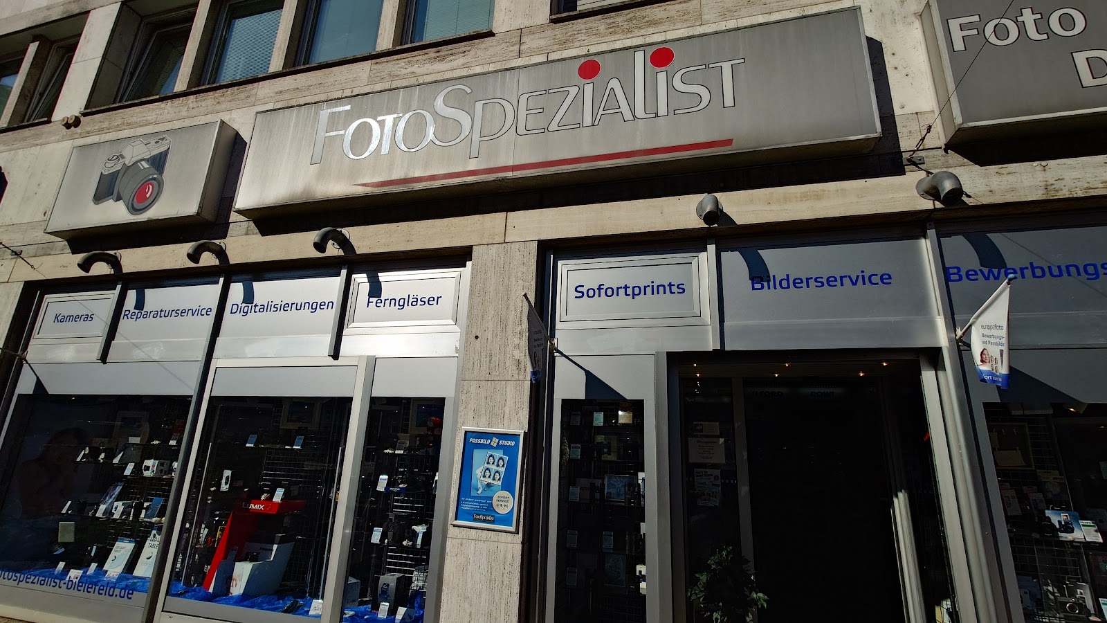 Leuchtschild Fotospezialist über dem Schaufenster